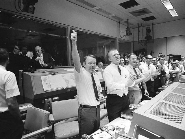 Three of the four Apollo 13 flight directors applaud the successful splashdown of the Command Module 